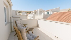 Une terrasse sur le toit, dotée d’un espace salon comprenant deux fauteuils confortables et une petite table.