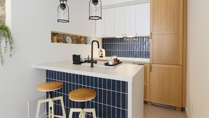 Une cuisine dotée d’un îlot central, de tabourets de bar, d’un évier et de meubles de rangement en bois.