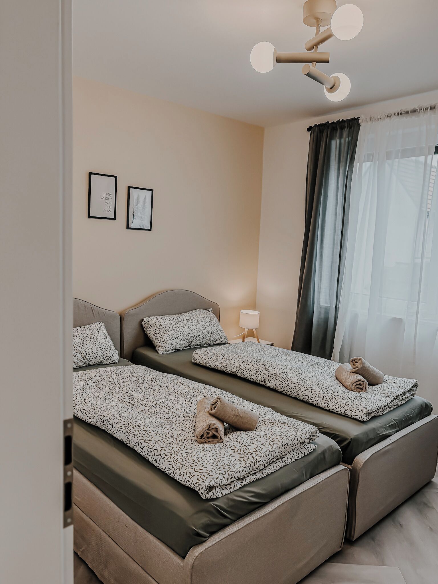 Une chambre d’hôtel avec un lit, une table de chevet, une lampe et deux tableaux encadrés au mur.