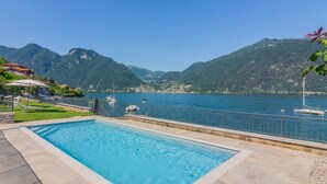 Uma piscina com vista para um lago e montanhas.