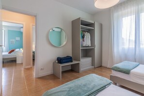 A bedroom with a bed, a desk, a wardrobe, and a mirror.