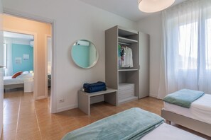 A bedroom with a bed, a desk with a suitcase, a wardrobe, and a mirror. - GuestHost - Charming 83 sqm apartment, accommodating up to 4 people, located on the first floor of a building without an elevator.The property is located in Lezzeno, in the province of Como, in an area equipped with all amenities and boasting a wonderful (Carvagnana)