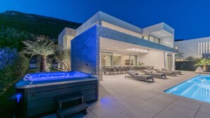A modern outdoor pool area with a hot tub, lounge chairs, and a dining area. - Villa4islands 1/Luxury stay, Epic sea view & 70 m2 Infinity pool (Kaštel Stari)