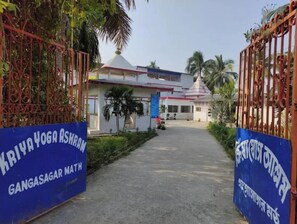 A gated entrance to a building with a sign reading "KRIYA YOGA ASHRAM GANGASAGAR MATH". - Kriya Yoga Wellness (Kakdwip)