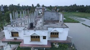 A two-story building with a flat roof, multiple windows, and a surrounding grassy area. - Kriya Yoga Wellness (Kakdwip)