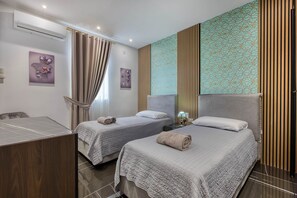 A hotel room with two beds, a desk, and a bathroom. - AzureGold Apartment (Senglea)