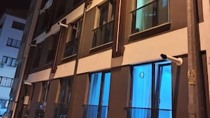 Een meerlaags gebouw met verschillende ramen, waarvan sommige voorzien zijn van gordijnen.