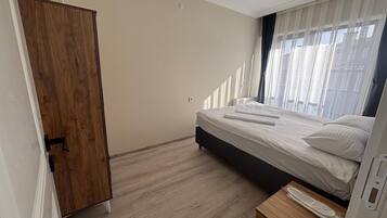 Un dormitorio con cama, armario de madera y mesita de noche.