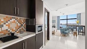 Una cocina moderna con armarios de madera oscura, salpicadero de azulejos y un microondas.