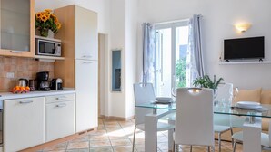 Una cocina moderna con microondas, cafetera y un bol naranja sobre la encimera.