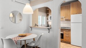 Eine moderne Küche mit weißen Schränken, einem Backofen und einem Kühlschrank.