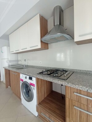 Departamento económico, balcón, vista al parque | Cocina privada | Refrigerador con congelador, parrilla de estufa y utensilios de cocina 