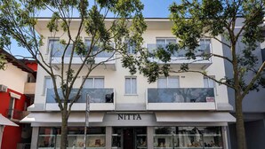 A building with a storefront labeled 'NITTA' featuring glass display windows. - Holiday apartment with air conditioning and balcony (Lignano Sabbiadoro)