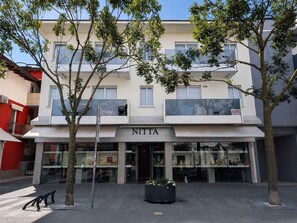 A building with a storefront labeled 'NITTA' featuring glass display windows. - Holiday apartment with air conditioning and balcony (Lignano Sabbiadoro)