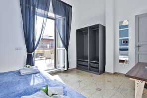 Une chambre à coucher avec un lit, une armoire, un bureau et une vue sur l’extérieur.