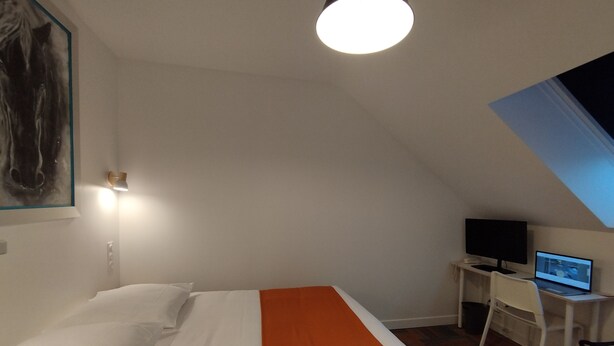 A bedroom with a bed, a desk with a computer, and a painting on the wall. - The Originals Access Hotel Le Canter (Saumur)