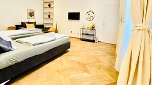 Un dormitorio moderno con una cama grande, una mesita de noche, un televisor y un espejo.