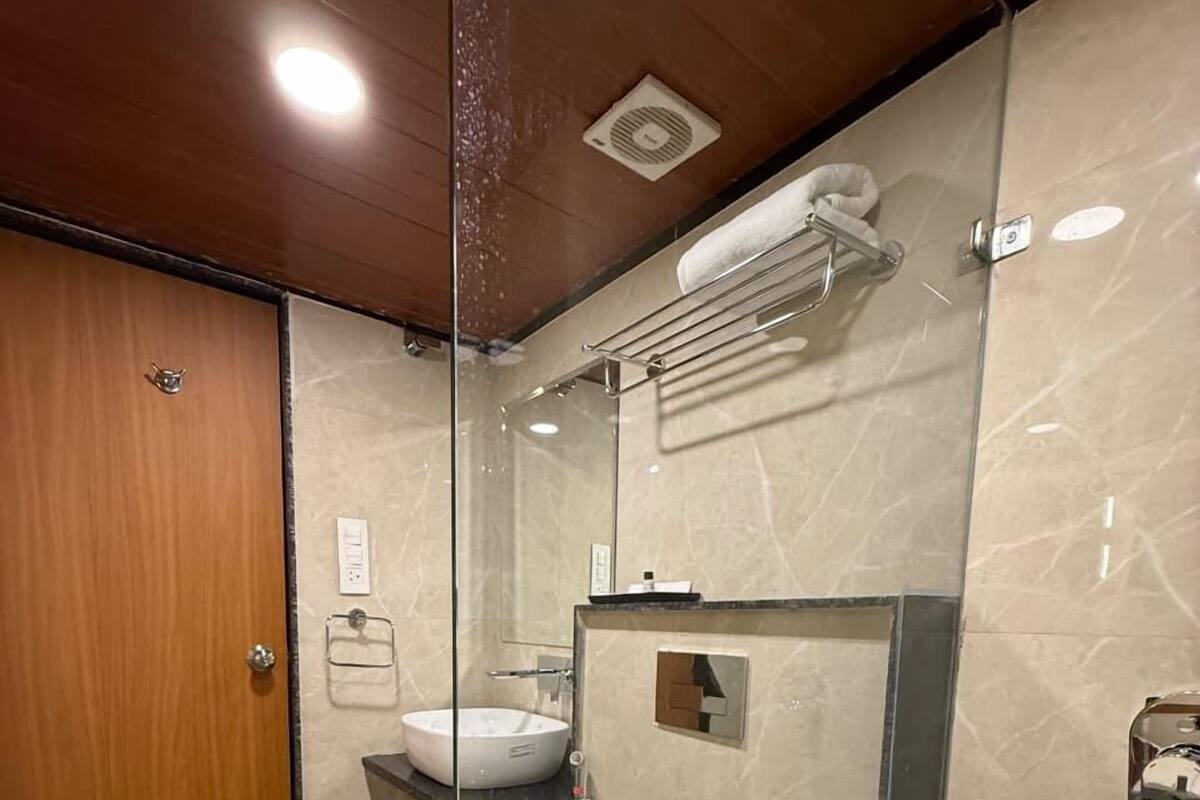 A modern bathroom with a glass partition, a toilet, a sink, and a shower area.