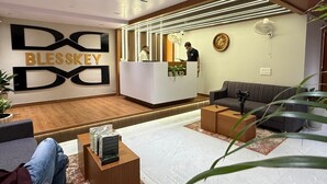 A modern hotel lobby with a reception desk, sofas, and a stage. - Hotel Blesskey (Jaipur)