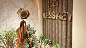 A room with a wooden floor, a tripod with a camera, and several potted plants. - Hotel Blesskey (Jaipur)