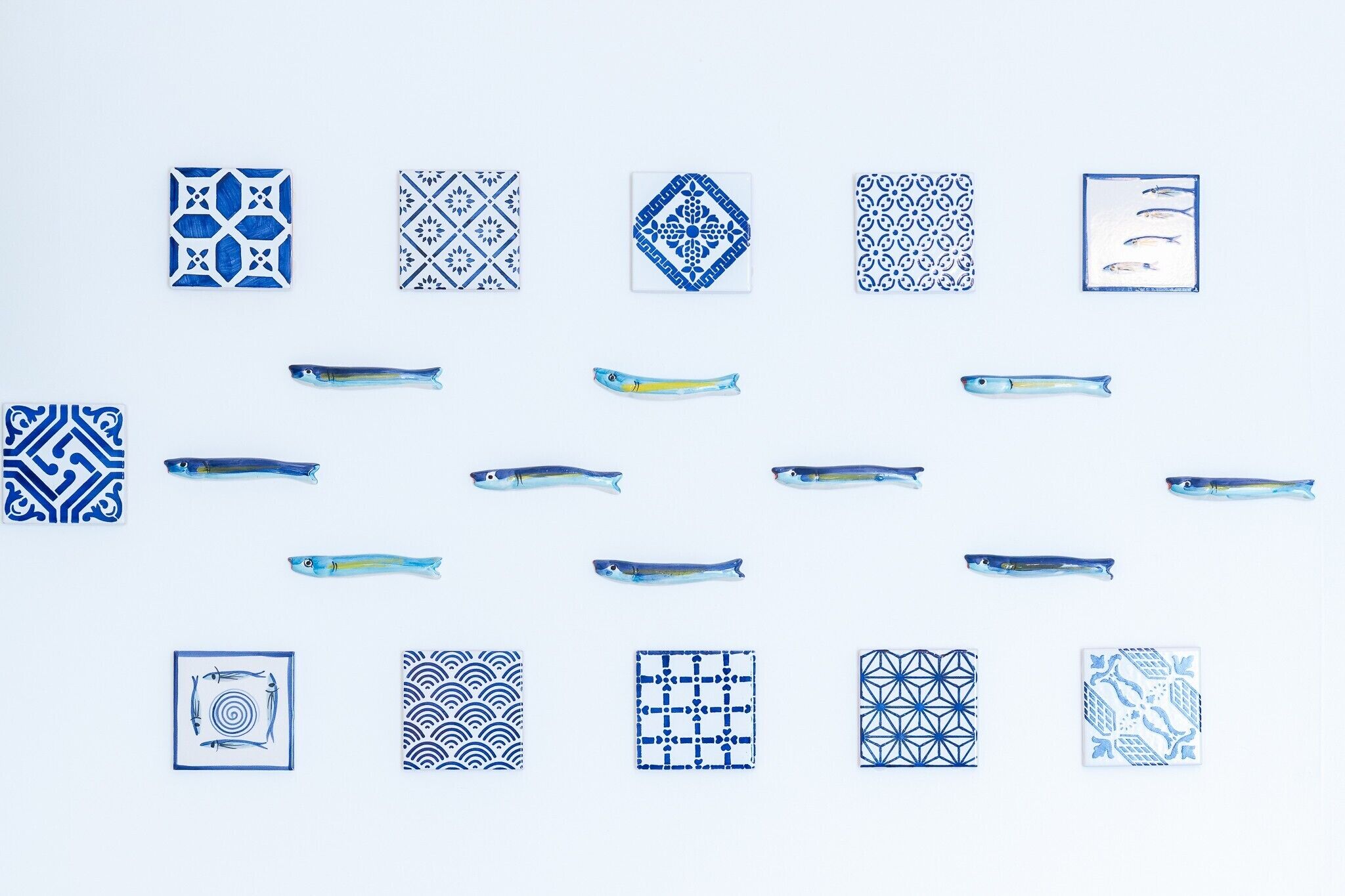 Une collection de carreaux aux motifs bleus et blancs, ainsi que d’illustrations de poissons.