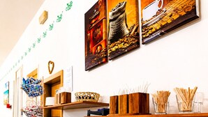 A buffet setup with various food items, a coffee station, and decorative wall art.