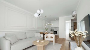 Een moderne woonkamer met een bank, een rond bijzettafeltje en een eethoek met stoelen en een tafel.