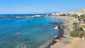 A coastal town with a beach, rocky shoreline, and a marina. - Vacation Apartment 'Sunshine Sea' with Sea View, Wi-Fi, and Air Conditioning (Arona)