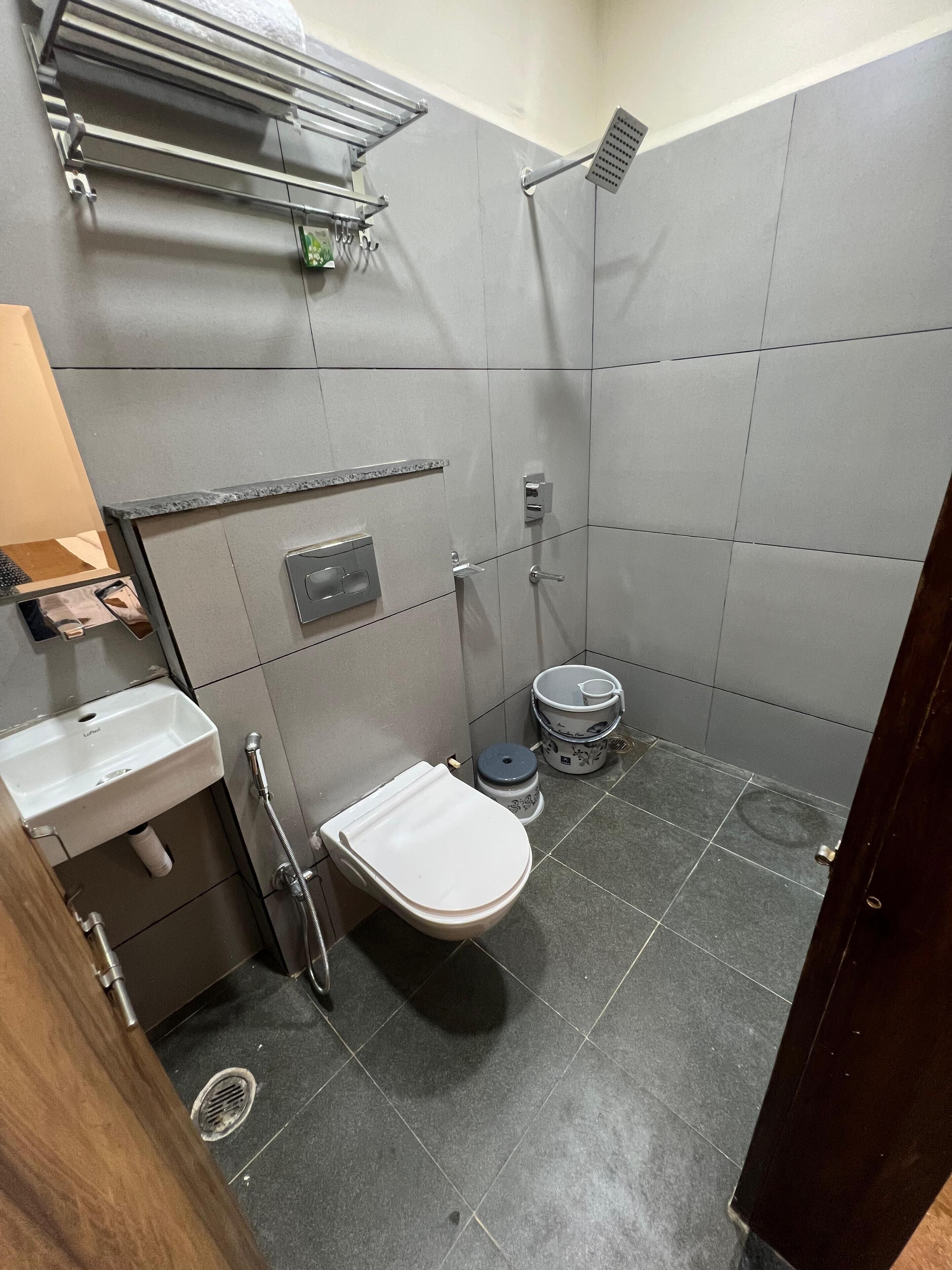 Un baño pequeño con azulejos, que incluye un inodoro, lavamanos y ducha.