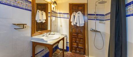 Un baño con lavamanos, espejo y ducha.