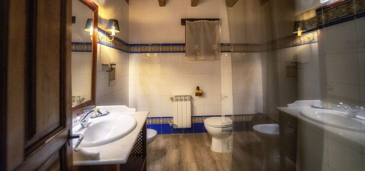 Un baño con dos lavamanos, inodoro y zona de ducha.