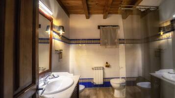 Ein Badezimmer mit Holzboden, einem Doppelwaschbecken, einer Toilette und einer Badewanne.