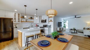 A modern kitchen with white cabinets, a central island, and pendant lighting. - Walk to Canal Trail! Condo w/ Pool in Scottsdale (Scottsdale)