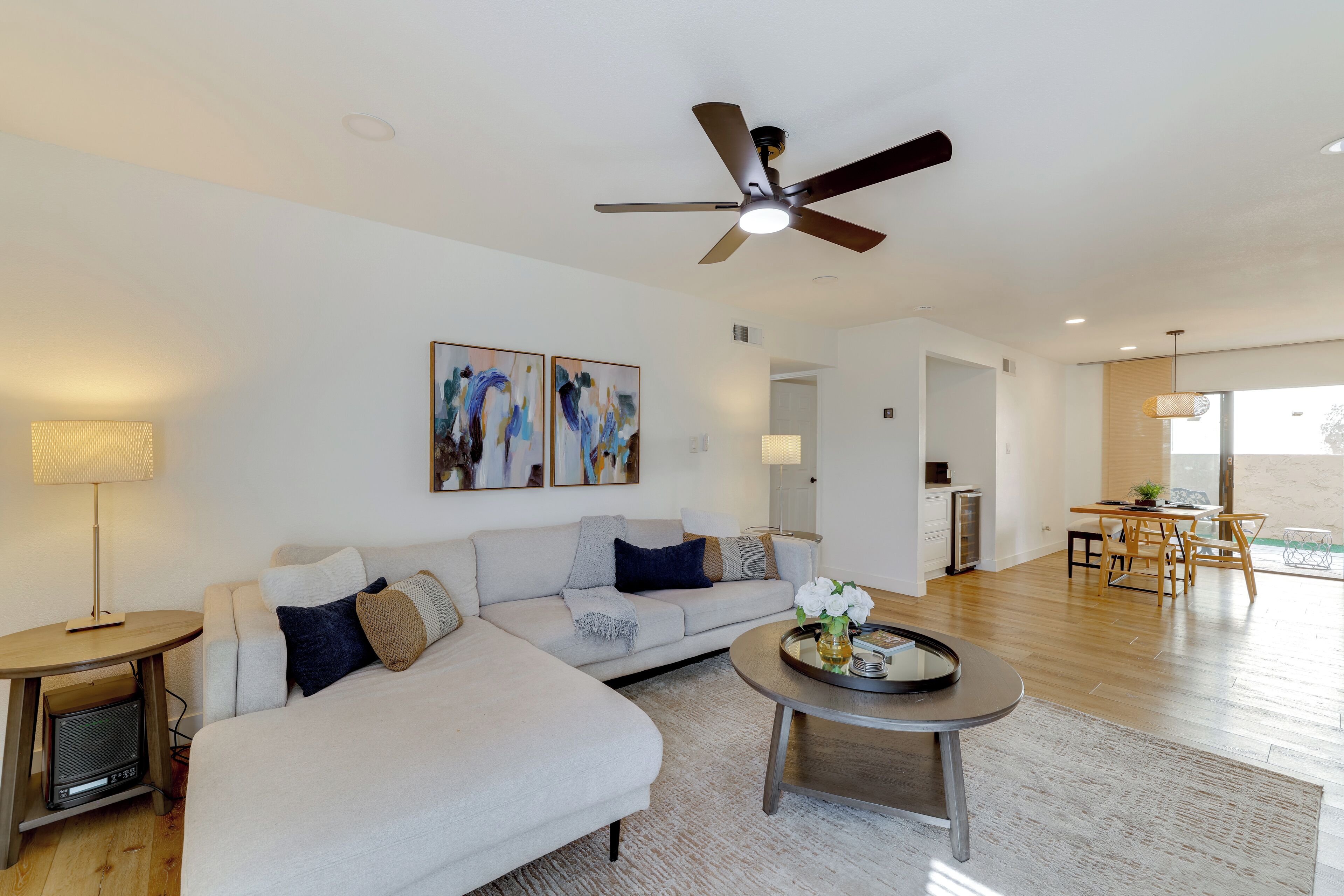A spacious living room with a sofa, coffee table, and artwork on the wall.