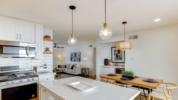 A modern kitchen with white cabinetry, stainless steel appliances, and pendant lighting. - Walk to Canal Trail! Condo w/ Pool in Scottsdale (Scottsdale)