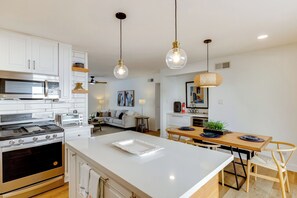 A modern kitchen with white cabinetry, stainless steel appliances, and pendant lighting. - Walk to Canal Trail! Condo w/ Pool in Scottsdale (Scottsdale)