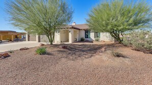 A house with a gravel driveway, two large trees, and a clear blue sky. - Enjoy Million-dollar Views! Lake Havasu City Home (Lake Havasu City)