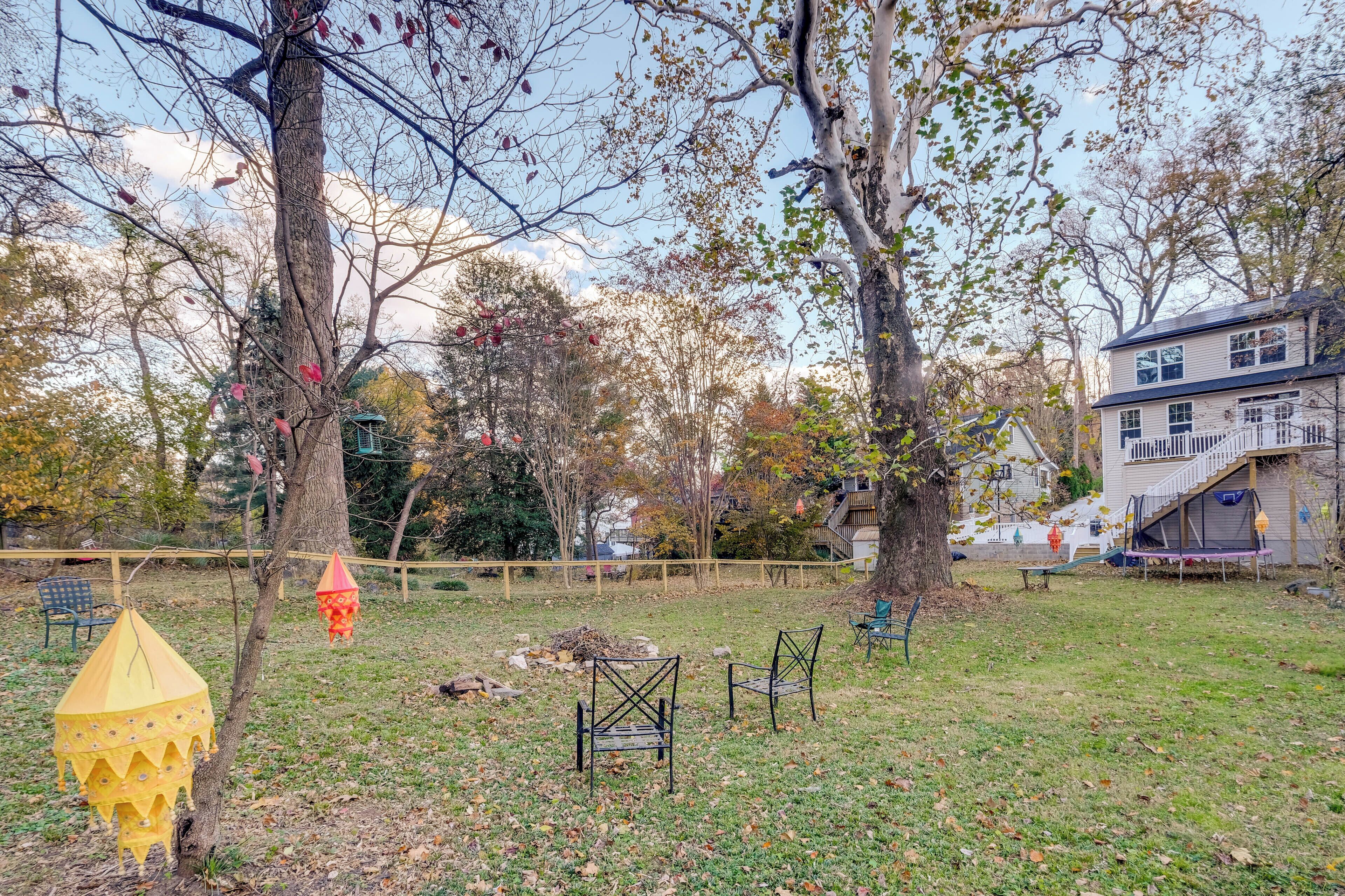 Un pati amb un arbre, caires i una casa al fons.