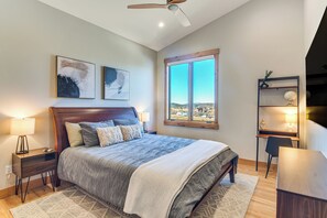 A bedroom with a large bed, a desk, and a view of the city. - 5 Mi to Winter Park Skiing & Dtwn: Mtn-view Condo (Fraser)