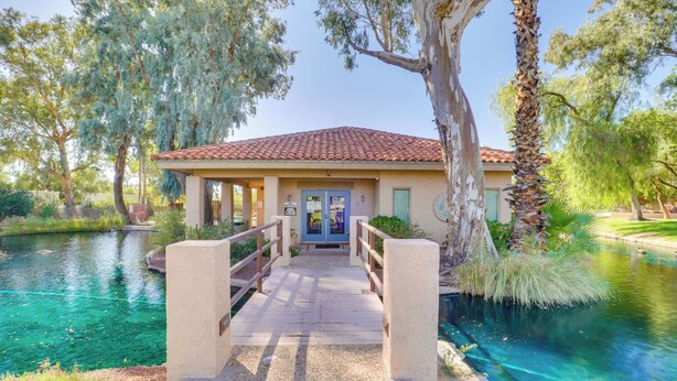A building with a red-tiled roof, a wooden bridge leading to the entrance, and a clear blue pool in the foreground. - Mtn-view Tucson Home Near Hiking & Biking (Tucson)