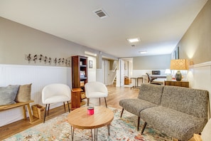 A living room with a sofa, two chairs, a coffee table, and a bookshelf. - Easy I-25 Access! Vibrant North Denver Home (Denver)