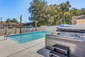 A swimming pool with a hot tub, surrounded by a fence, trees, and houses in the background. - Hot Tub + Pool: Home Near Dtwn Little River! (Little River)