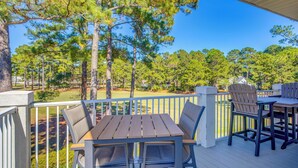 A wooden deck with a table and chairs, surrounded by a white railing, overlooking a golf course. - Golfer's Haven: Calabash Condo, 9 Mi to Beach (Calabash)