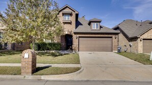 A residential house with a brick facade, a front garage, and a well-maintained lawn. - 3,000-sq-ft Family Home in Anna w/ Game Room! (Anna)