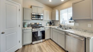 A modern kitchen with white cabinetry, stainless steel appliances, and a granite countertop. - 'mountain Family Getaway' in Colorado Springs! (Colorado Springs)