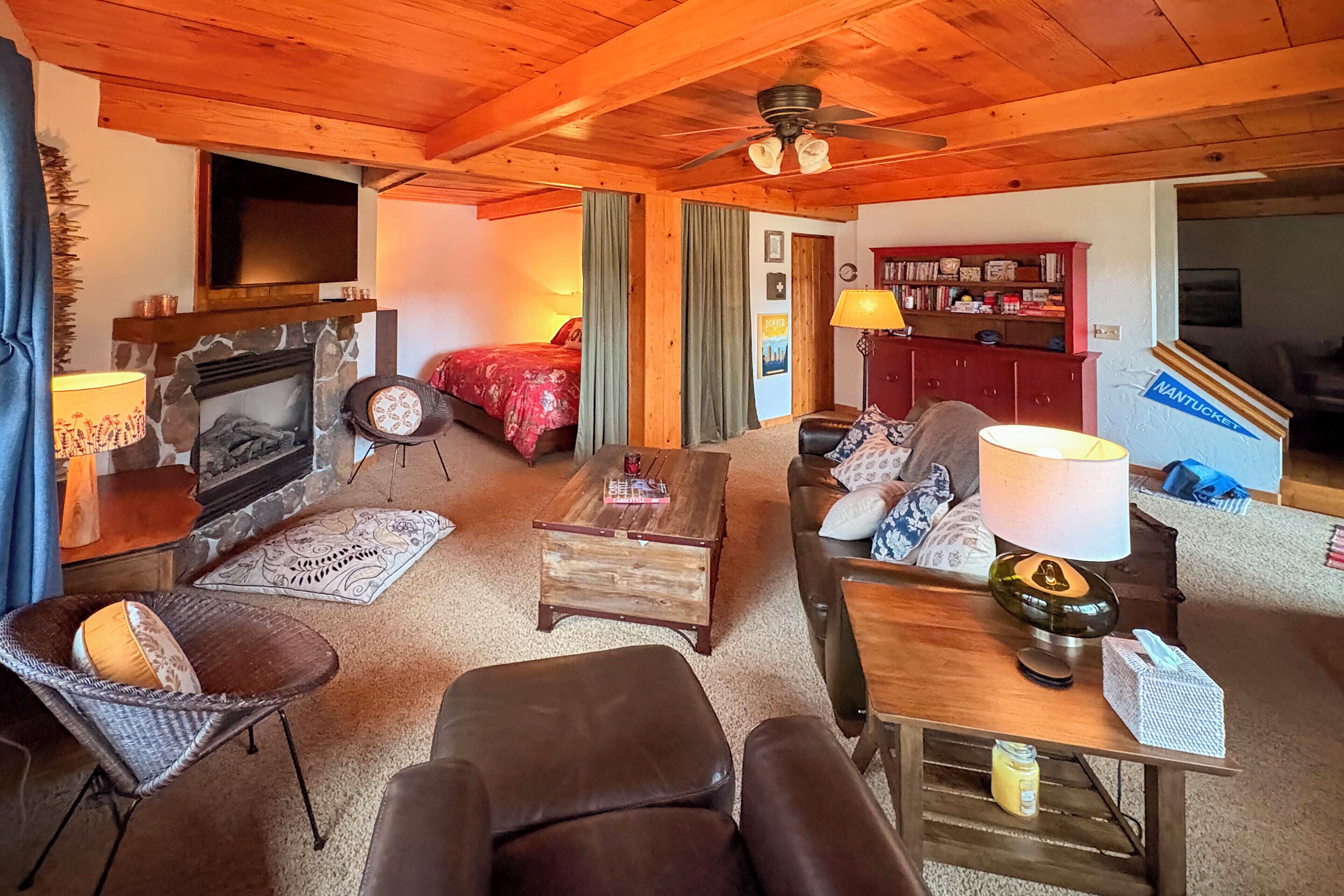 A cozy living room with a fireplace, comfortable seating, and a bookshelf.