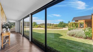 Un intérieur moderne avec de grandes portes-fenêtres coulissantes donnant sur un jardin bien entretenu.