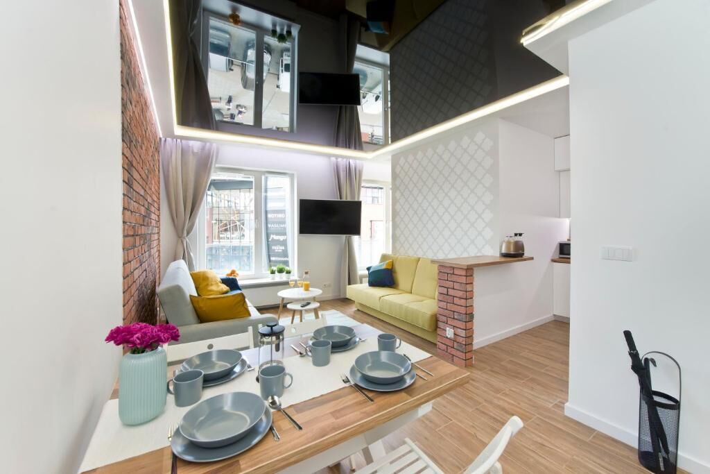 A modern apartment with a dining area, kitchen, and living space.
