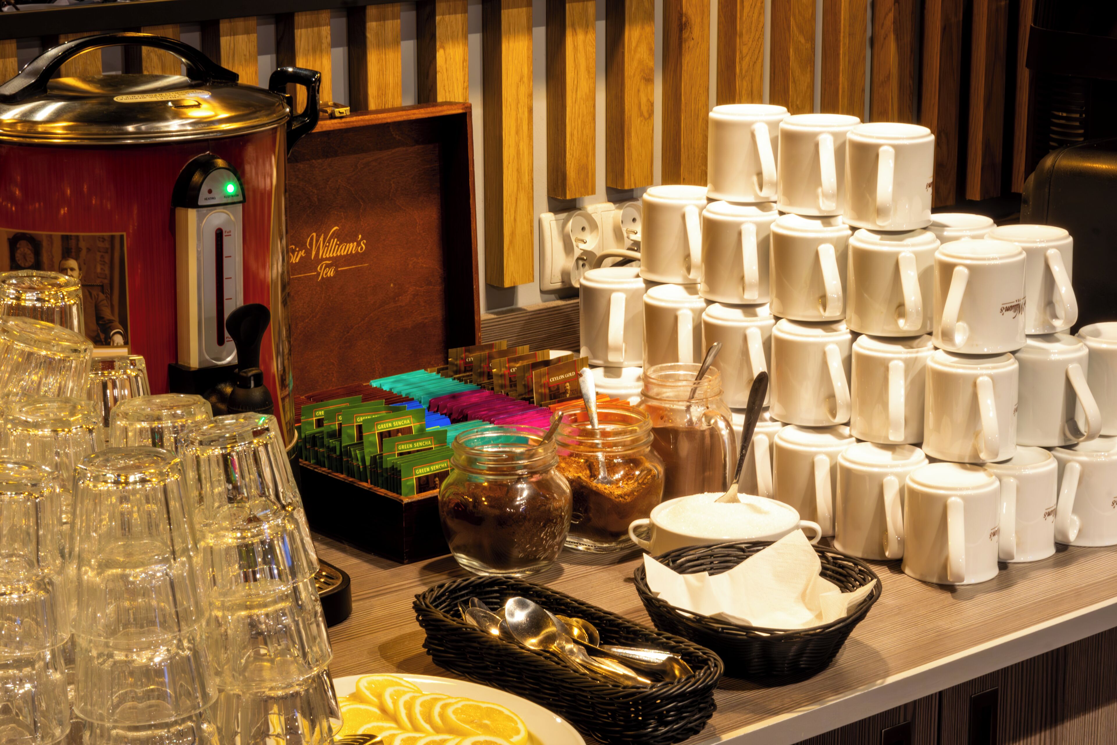 Un buffet proposant une variété de plats, de couverts et un coin pour préparer le thé.