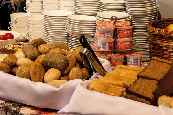 A buffet with various breads, pastries, and dairy products. - Noclegi Hit Rooms & Apartments (Warsaw)